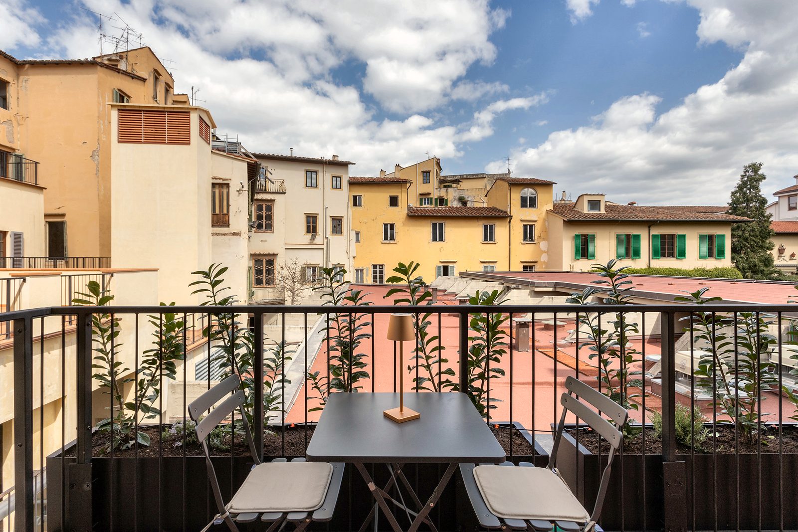 Studio Duomo Michelangelo: private terrace with a bistro table, lemon plants and a view over ochre Florentine façades